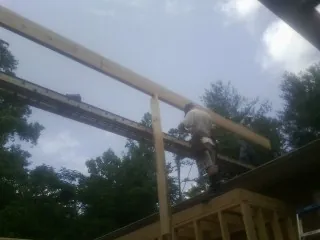 Carpenter setting a ridge beam over a new addition frame — Ice Dam Removal by Roofing Brothers in Sutherland