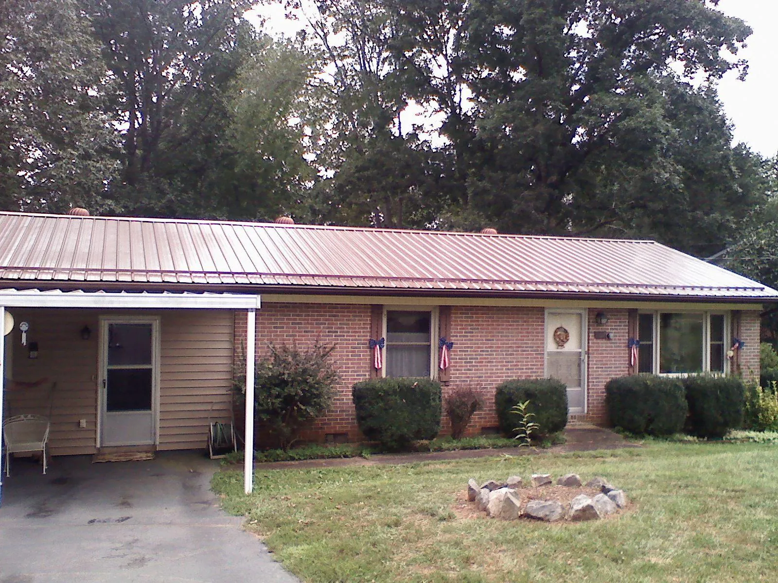 Bronze metal roof and carport on a brick ranch home — Roof Repair work by our crew in Sutherland